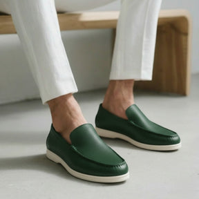 Green leather loafer by San Valier with a textured surface, paired with white trousers.