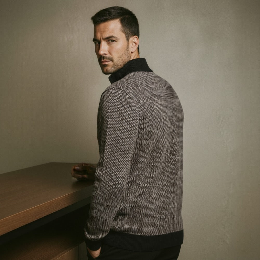 Gray knit quarterzip sweater by San Valier, with a textured pattern and black collar, worn by a man looking over his shoulder.
