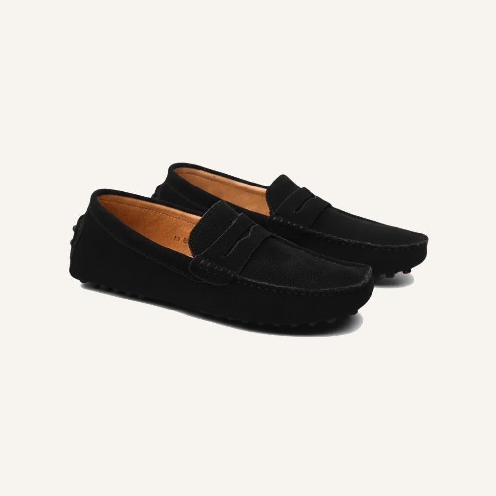 Black suede driver loafers by San Valier, featuring a minimalist penny loafer strap and moccasin stitching detail.